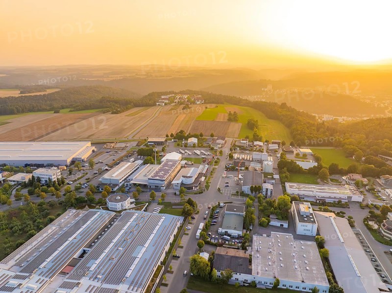 Industrial area in hilly landscape, surrounded by fields, at atmospheric sunset, industrial area Wolfsberg Nagold, district Calw, Black Forest, Germany