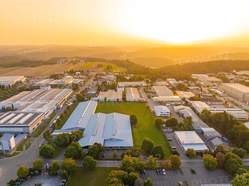 Industrial complex with surrounding green areas and fields at sunset, industrial area Wolfsberg Nagold, district Calw, Black Forest, Germany