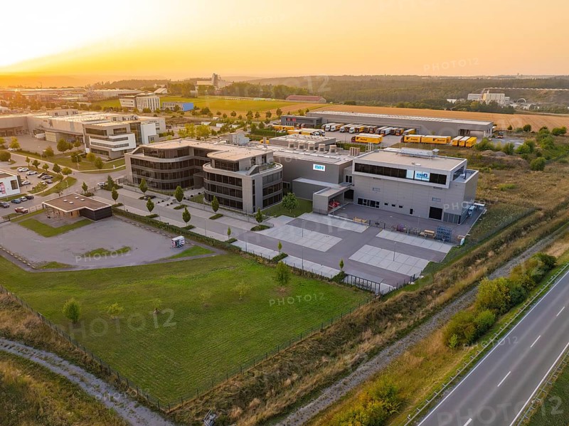 Commercial area with modern buildings and streets in a rural setting in the evening, industrial area Wolfsberg Nagold, district of Calw, Black Forest, Germany