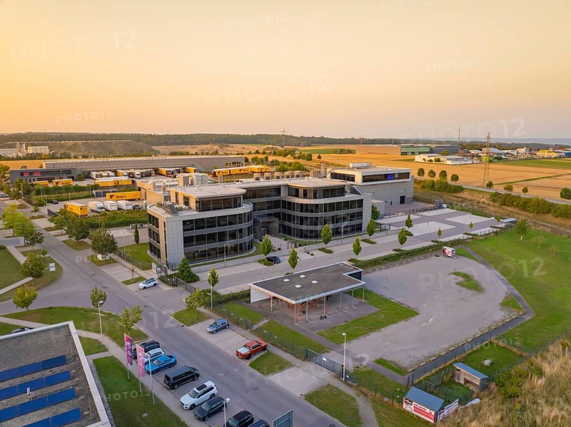Modern office buildings and car parks in an urban setting at sunset, Wolfsberg Nagold industrial area, Calw district, Black Forest, Germany