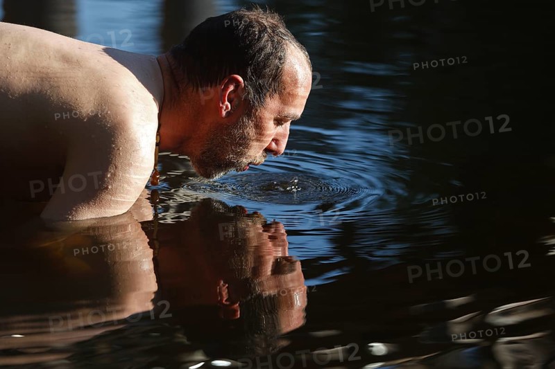 Man in the water during body care while travelling, Müritz National Park, Mecklenburg-Western Pomerania, Germany