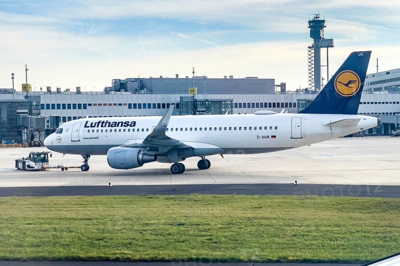 Lufthansa Airbus A320-200 being towed by a tug on the apron, in the background terminal and modern high tower airport tower, Düsseldorf International Airport DUS, Düsseldorf, North Rhine-Westphalia, Germany