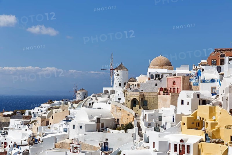 White and colourfully painted holiday homes on a steep slope, windmills, Cumulus, view of Oia, Thira, Santorini, Cyclades, Greece