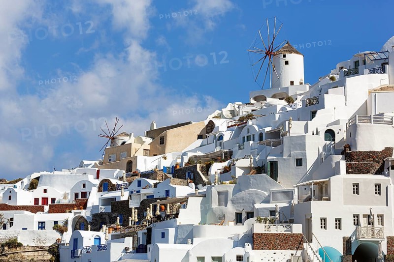 Whitewashed holiday homes, two windmills on the hillside, Cumulus, Oia, Thira, Santorini, Cyclades, Greece