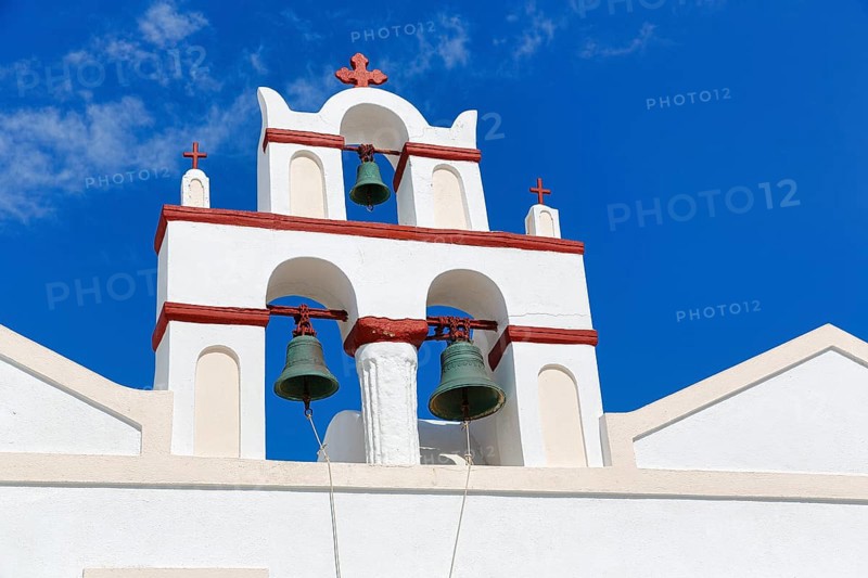 Bell tower of an orthodox church in typical Cycladic architecture with whitewashed walls and red crosses, Old Town, Oia, Thira, Santorini, Cyclades, Greece