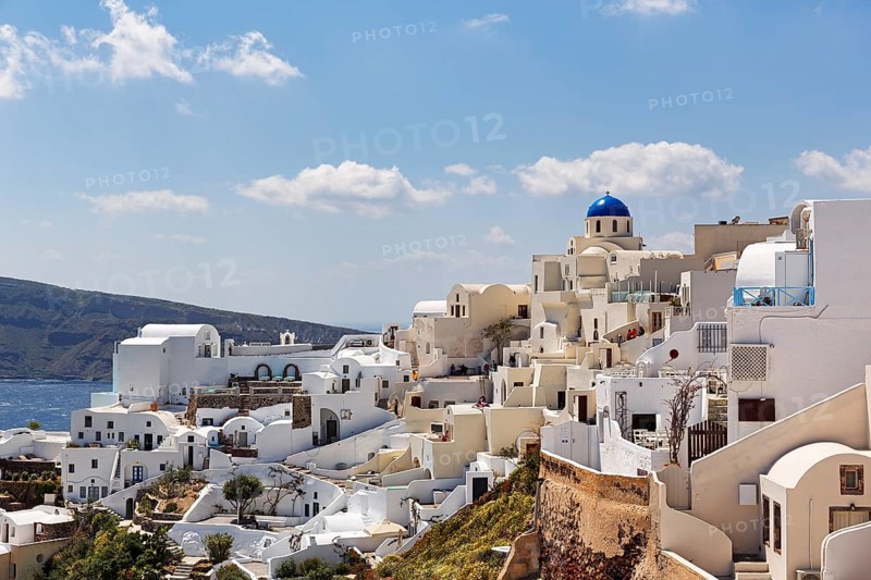 White holiday homes, orthodox church with blue dome on the edge of the caldera, Cumulus, Oia, Thira, Santorini, Cyclades, Greece