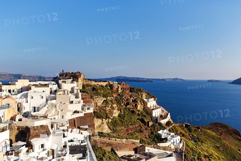 White houses on a cliff, castle of St Nicholas, Agios Nikolaos, view of the caldera, Oia, Thira, Santorini, Cyclades, Greece
