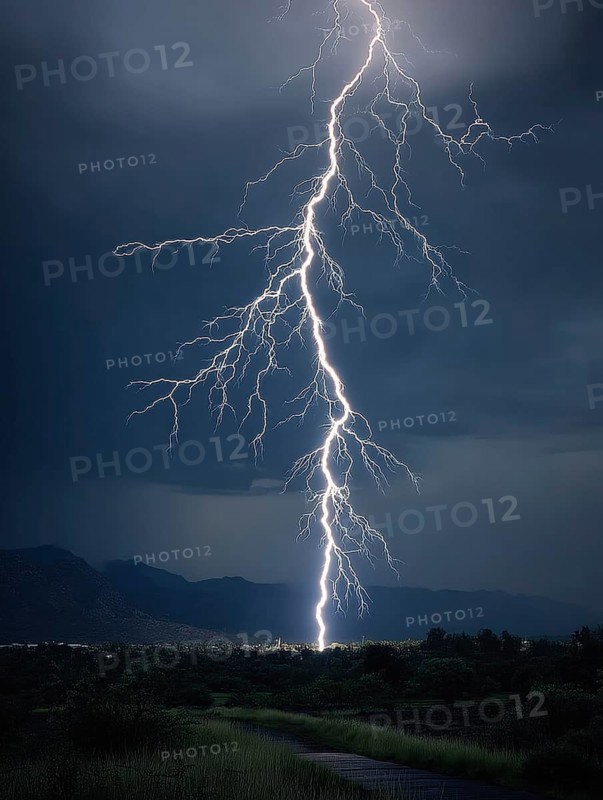 A large bolt of lightning strikes the night landscape, the dark sky menacing and impressive, AI generated