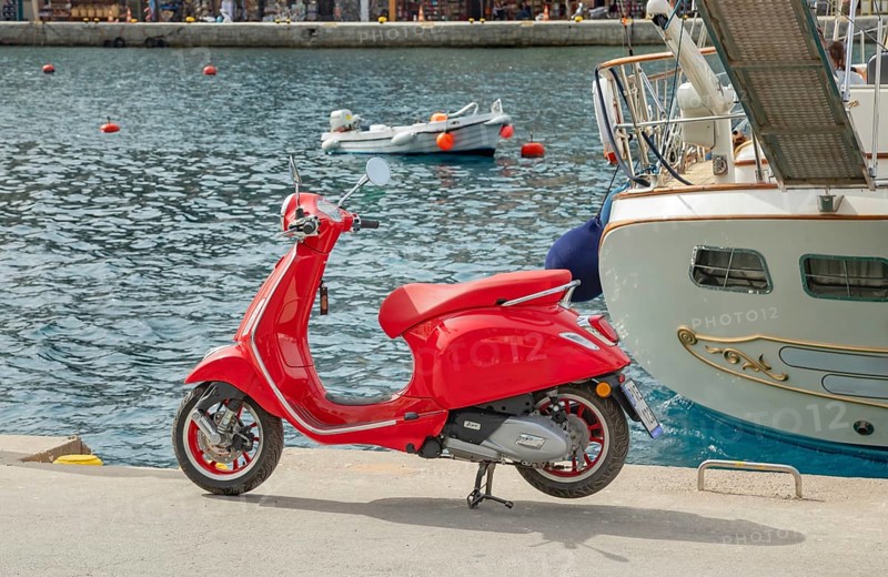 Red vespa scooter parked at Gialos harbour, Gialos, Symi Island, Dodecanese Islands, Greece
