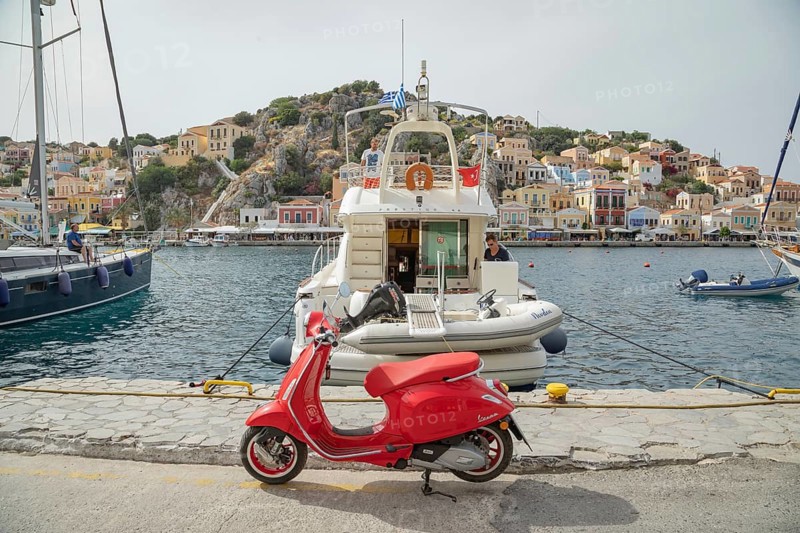 Red vespa scooter parked at Gialos harbour, Gialos, Symi Island, Dodecanese Islands, Greece
