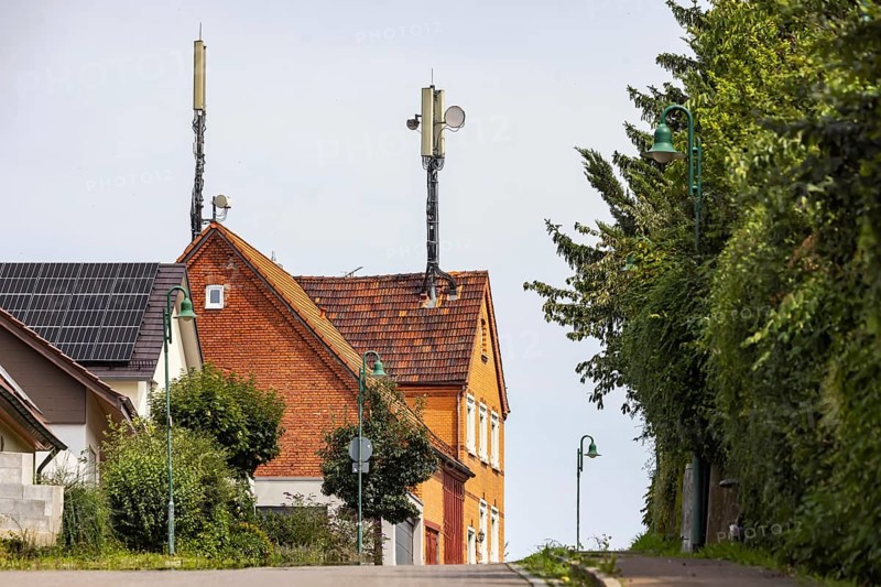Mobile phone mast on a house roof in a rural area. Ohmden, Baden-Württemberg, Germany