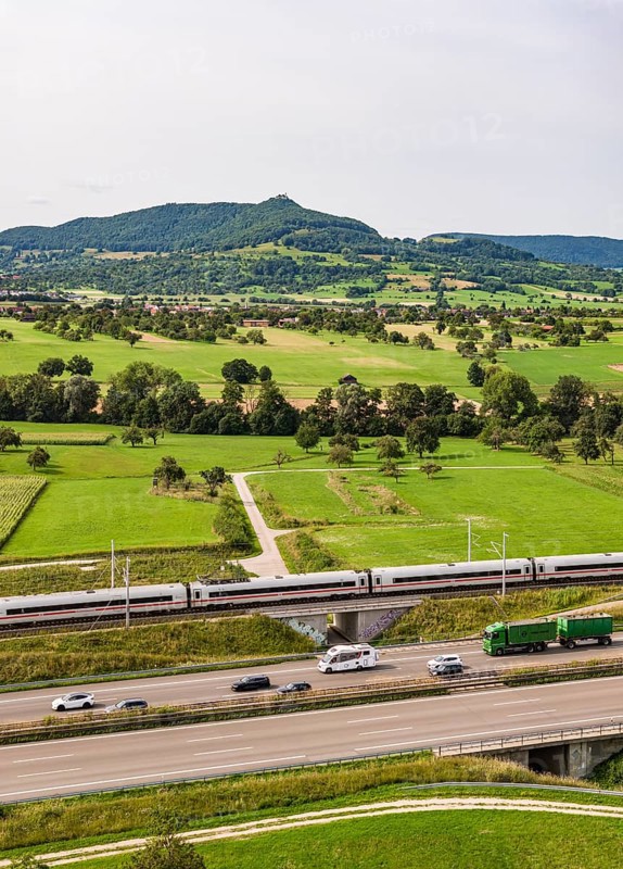 A8 motorway near Kirchheim unter Teck. The route of the new high-speed railway line from Stuttgart to Ulm runs parallel to the road. Deutsche Bahn ICE train. The Swabian Alb with Teck Castle in the background. Kirchheim unter Teck, Baden-Württemberg, Germany