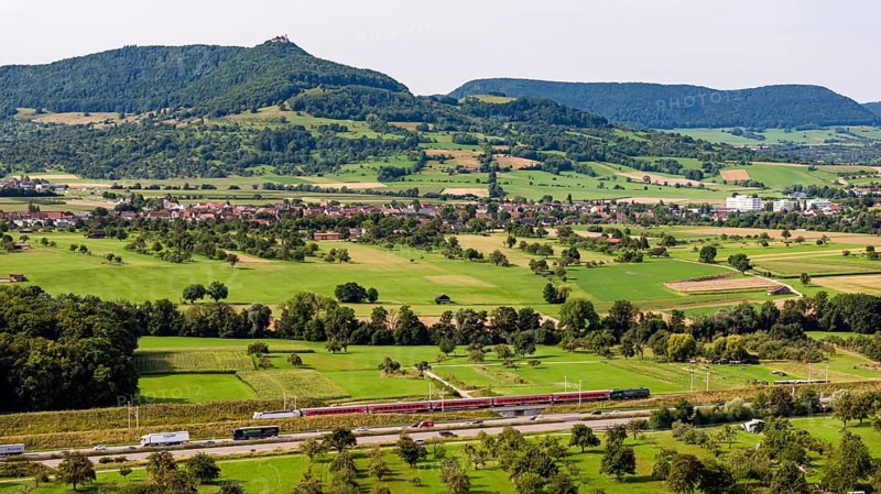 A8 motorway near Kirchheim unter Teck. The route of the new high-speed railway line from Stuttgart to Ulm runs parallel to the road. Regional train RE200. The Swabian Alb with Teck Castle in the background. Kirchheim unter Teck, Baden-Württemberg, Germany