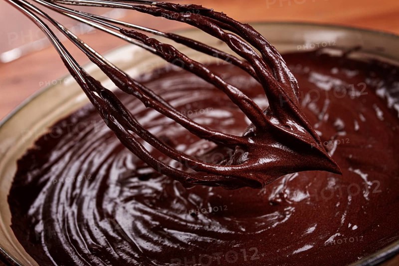 A bowl of chocolate dough, a whisk for whipping, baking, structure and consistency, homemade, top view, no people
