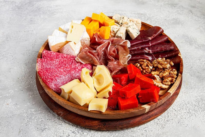Assortment of cheese meat cuts, on a plate, top view, no people