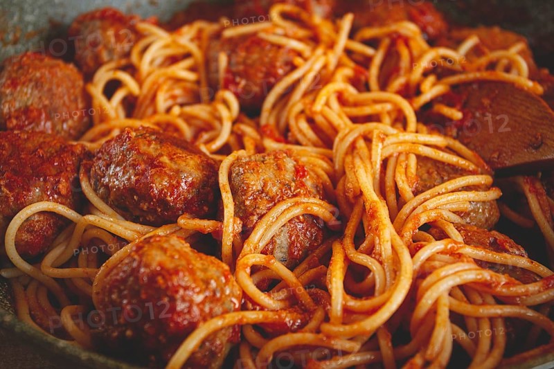 Spaghetti with meatballs, in tomato sauce, cooking in a frying pan, no people, homemade