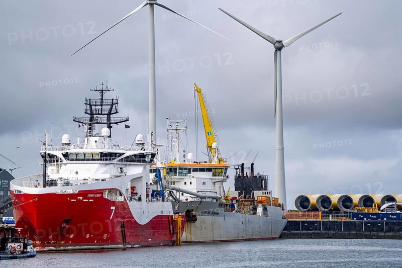 Working vessels in the seaport of Eemshaven, dredger Vitus Bering, aft, cable layer and offshore supply and working vessel Seaway Aimery, Netherlands