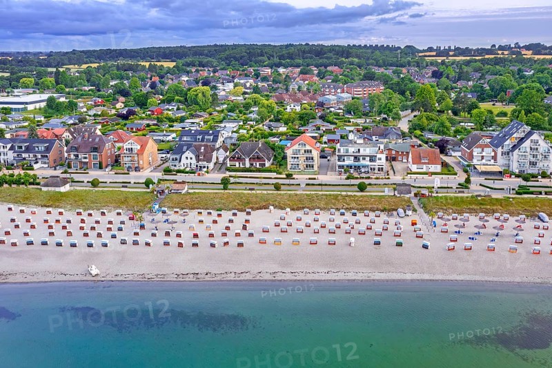 Aerial view over sandy beach with roofed wicker beach chairs and seaside resort Haffkrug along the Baltic Sea, Scharbeutz, Schleswig-Holstein, Germany