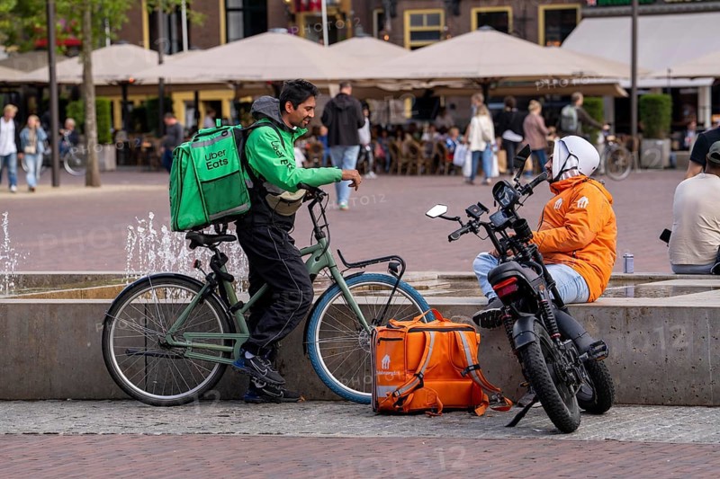 Bicycle transport in Groningen, Uber Eats, courier driver waiting for new orders, thuisbezorg.nl messenger with moped-style e-bike, Fatbike, Netherlands