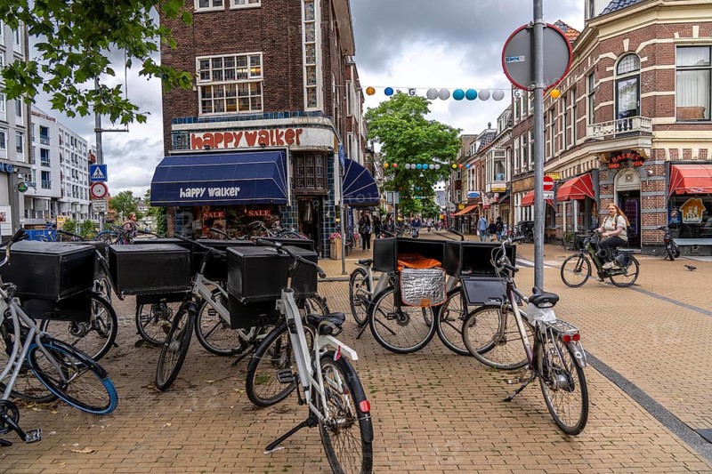 Riding a bike in the city centre of Groningen, old town, parked courier bikes, food delivery services, Netherlands