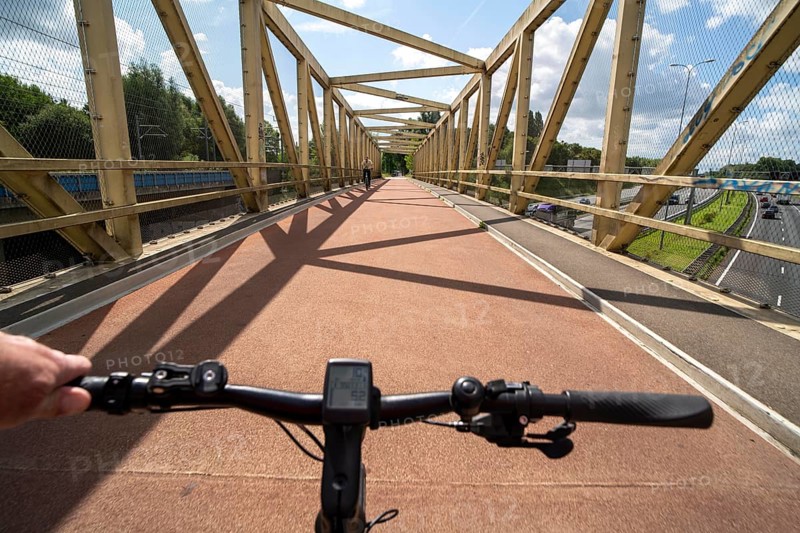 Cycling south of Utrecht, cycle path bridge over a motorway, long-distance cycle path to Houten, around 50, 000 people live here and work in the region, the traffic concept is consistently geared towards cycling, cars remain on the outskirts of the city districts, very well-developed cycling infrastructure, considered a model city in the Netherlands, Utrecht