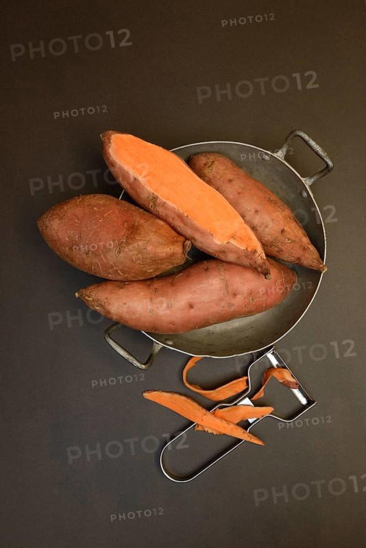 Sweet potatoes in skin with potato peeler, Ipomoea batatas