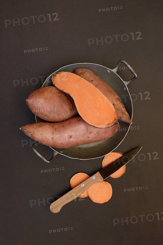 Sweet potatoes in their skins with kitchen knife, Ipomoea batatas