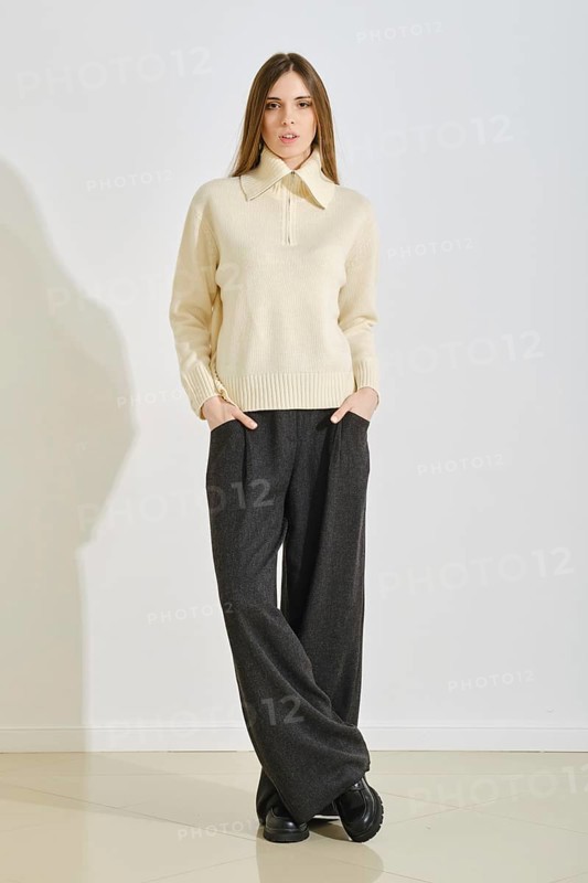 A young woman stands confidently in a stylish, cozy winter outfit that emphasizes convenience and practicality