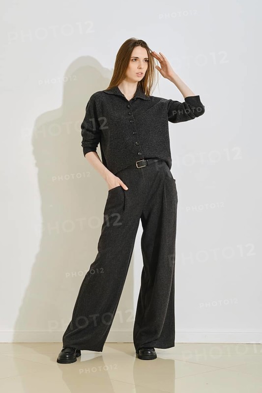 A stylish woman stands confidently in a trendy outfit, combining comfort and practicality