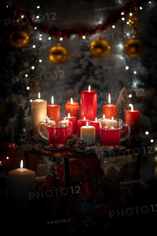 Table with red and white candles and cups, Christmas atmosphere with lights