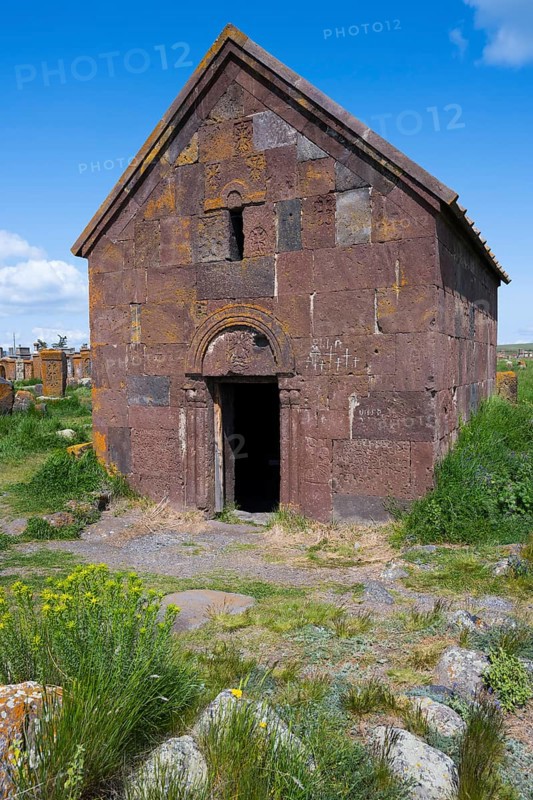 Old Armenian stone church with vaulted entrance surrounded by green landscape, Noratus cemetery, Noradus, Gegharkunik province, Armenia