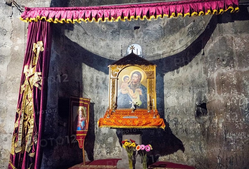 An altar with a religious icon surrounded by curtains and flowers in a decorated interior, Hajravank Monastery, Hayravank, Lake Sevan, Gegharkunik Province, Armenia