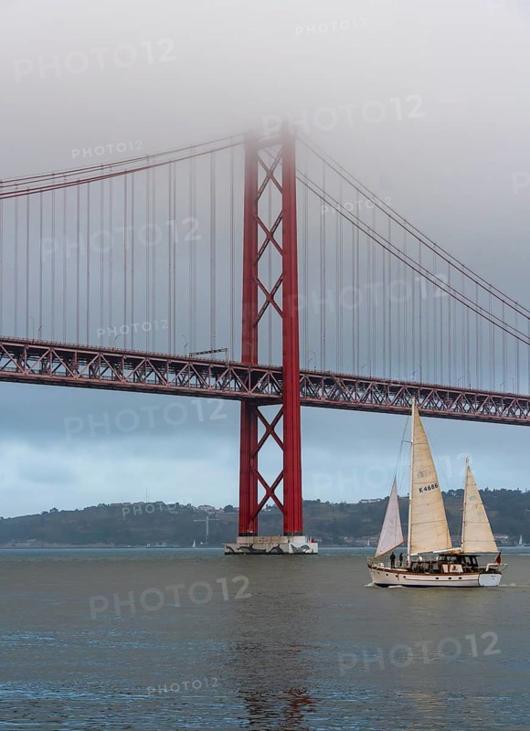 The Ponte 25 de Abril, 3.2 km long bridge in Portugal with a 2278 meter long suspension bridge across the Tagus, cloudy and rainy weather, third-longest suspension bridge with combined road and rail traffic, Lisbon, Portugal