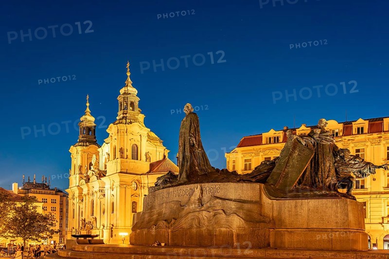 The Baroque St. Nicholas Church and the Jan Hus Memorial on Old Town Square at dusk, Prague, Czech Republic