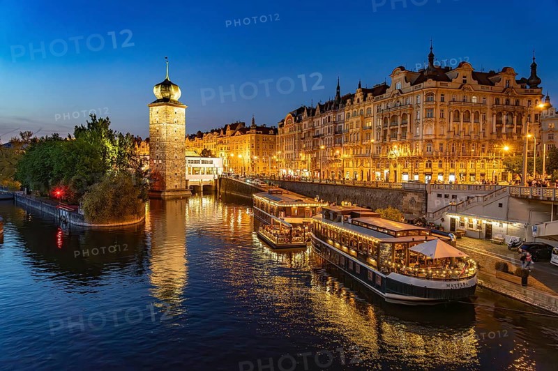 Hotel boats on the banks of the Vltava river and Sitkov water tower at dusk, Prague, Czech Republic