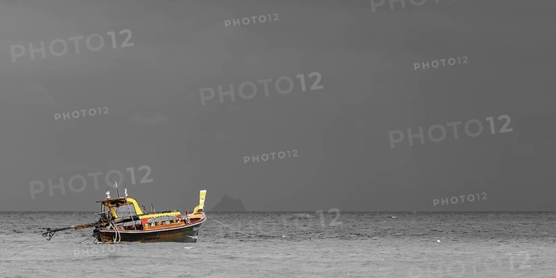 Longtail boat (Thai: Ruea Hang Yao) on the beach, behind it an approaching thunderstorm, Koh Ngai island, Andaman Sea, Satun province, southern Thailand, Thailand
