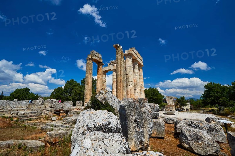 Ancient remains and columns surrounded by large stones under a cloudless sky, Nemea, Ancient Zeus Church, Archaeological Site, Peloponnese, Greece