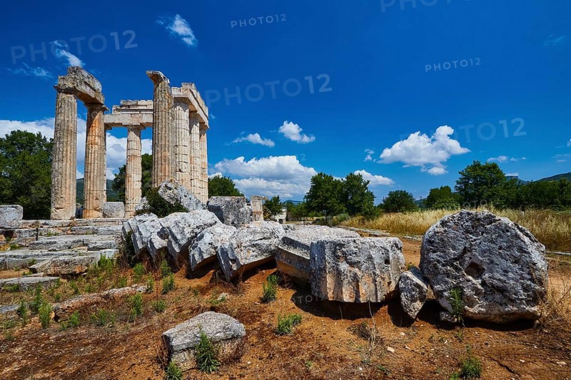 Stone columns and fragments against a clear blue sky in an open landscape, Nemea, Ancient Zeus Church, Archaeological Site, Peloponnese, Greece