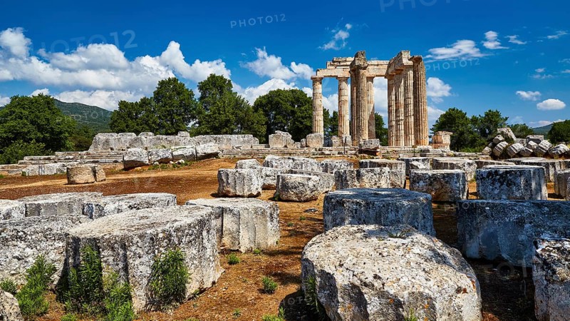 Stone ruins with ancient columns against a blue sky and clouds, Nemea, Ancient Zeus Heightum, Archaeological Site, Peloponnese, Greece