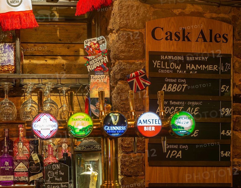 Cask ale menu of different brands inside the Ship pub, Exeter, Devon, England, UK - keg beer taps in foreground