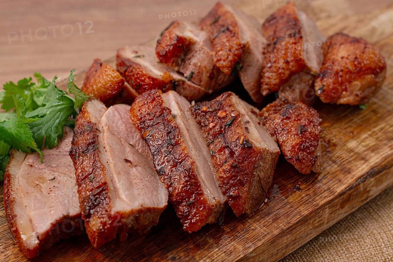 Roast duck breast, sliced, on a wooden chopping board, close-up, no people