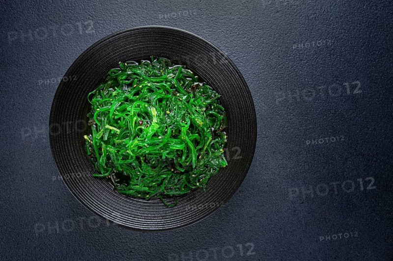 Chuka salad, made from fresh seaweed, with sesame dressing, served in a black bowl