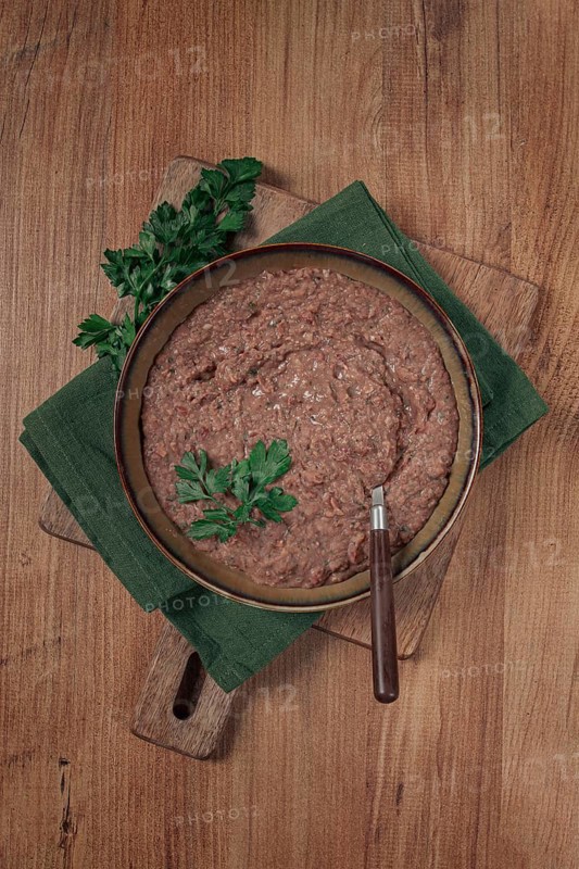 Red bean lobio, a traditional Georgian dish, on a wooden table, homemade