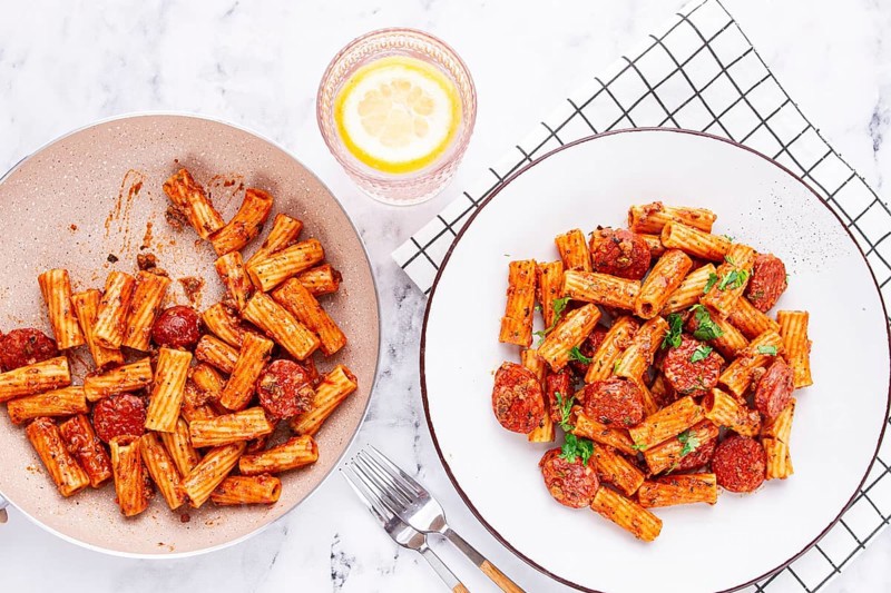 Rigatoni pasta with spicy sausage, and rich tomato sauce served, on a white plate, homemade