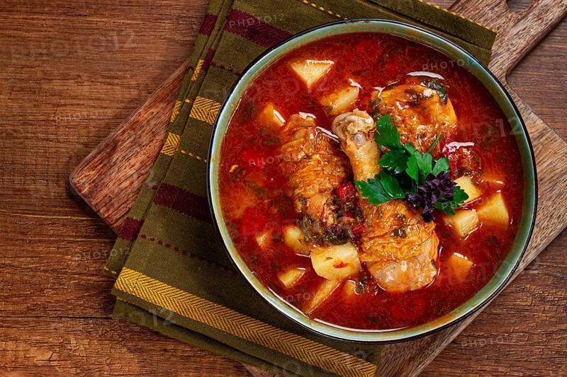 Souzi soup. Georgian dish, meat with oats, tomato sauce and herbs, on a wooden table
