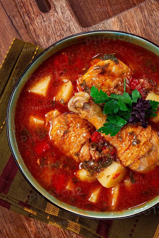 Souzi soup. Georgian dish, meat with oats, tomato sauce and herbs, on a wooden table