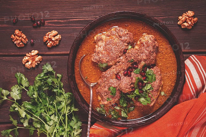 Fesenjan, an Iranian dish, stewed chicken, in walnut-pomegranate sauce, in an earthen pan, homemade, no people