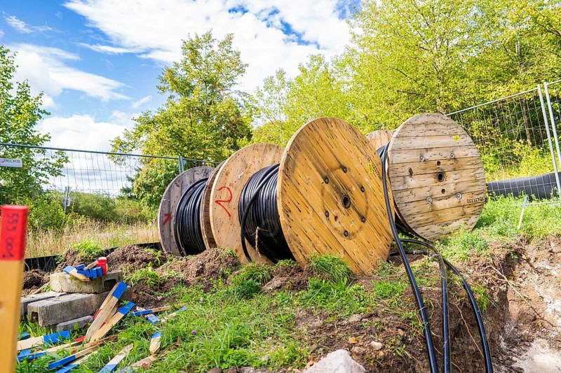 Several large cable drums with cables on a construction site in a green area, Bau PV Freifaechenanlage, Weil der Stadt, Germany