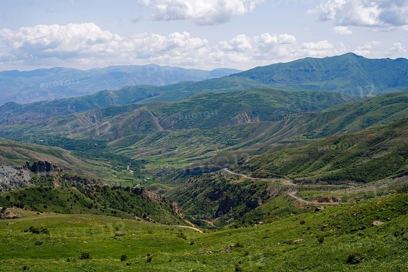 Rolling hills and mountains around a wide valley with green vegetation, cloudy sky, views from Vardenyats Pass or Selim Pass, Vayots Dzor Province, Armenia