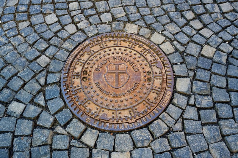 Round metal manhole cover on paved ground with interesting structure, manhole cover, Hünfeld, Konrad-Zuse-Stadt, Hesse, Germany